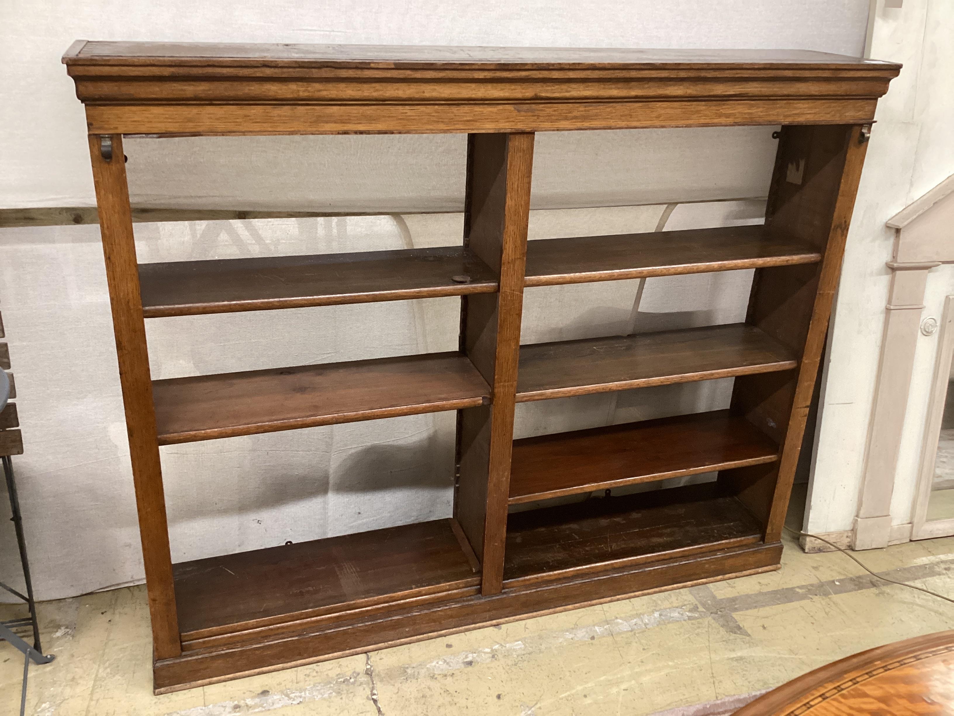 An Edwardian oak open bookcase, width 150cm, depth 28cm, height 122cm (adapted)
